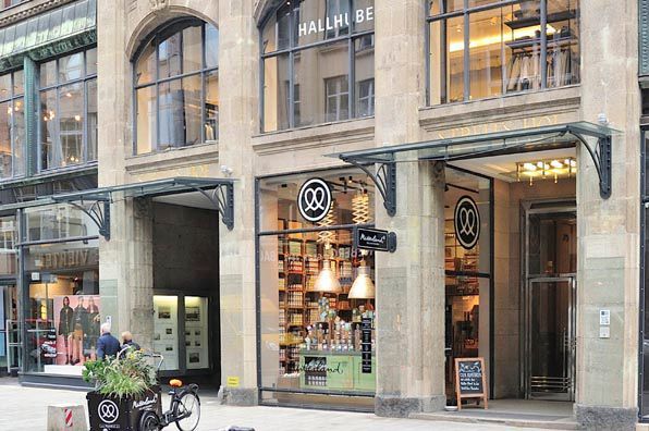 Ein Mann fährt vor einem Gebäude Fahrrad.