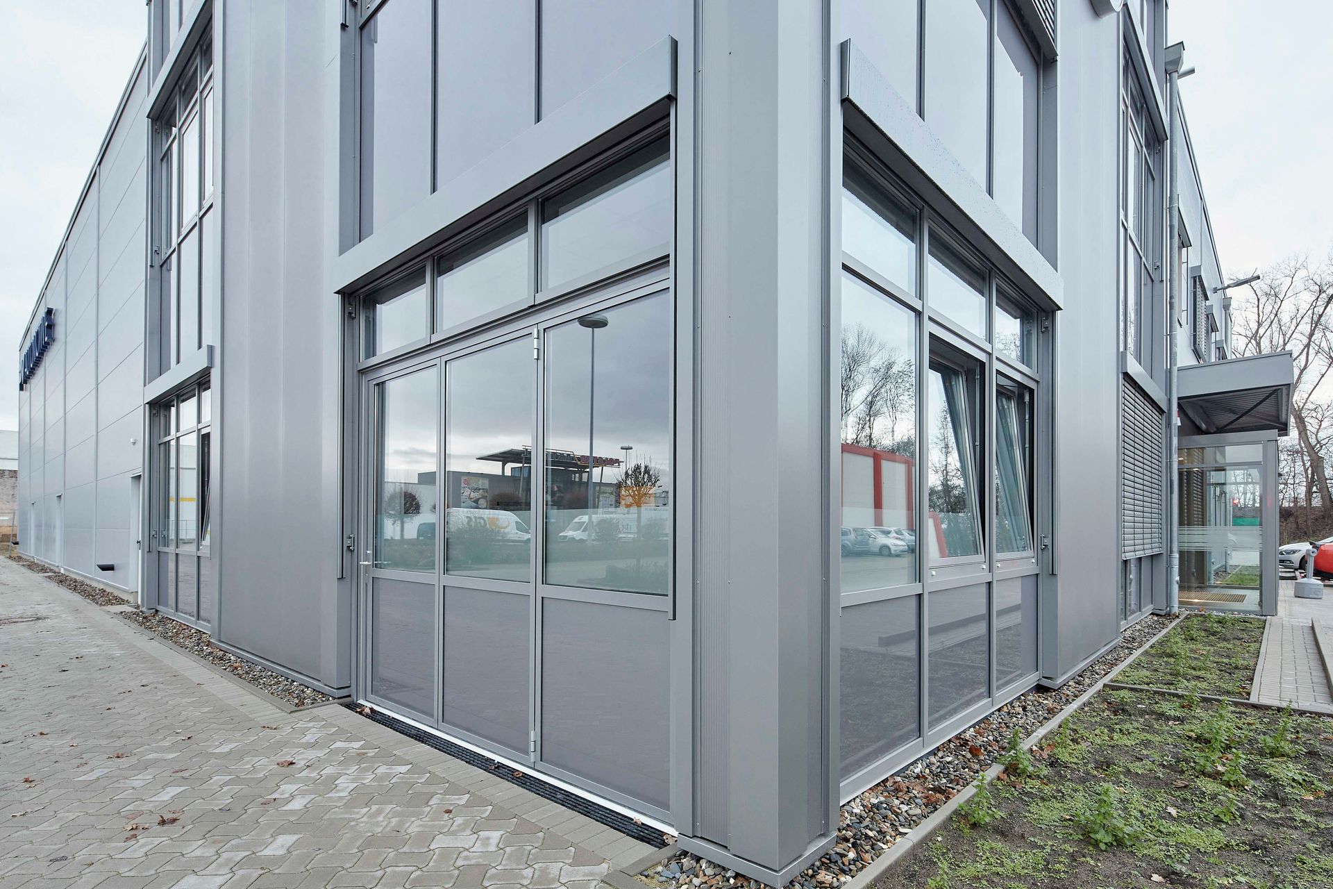 Ein großes Gebäude mit vielen Fenstern und einem davor geparkten Auto.