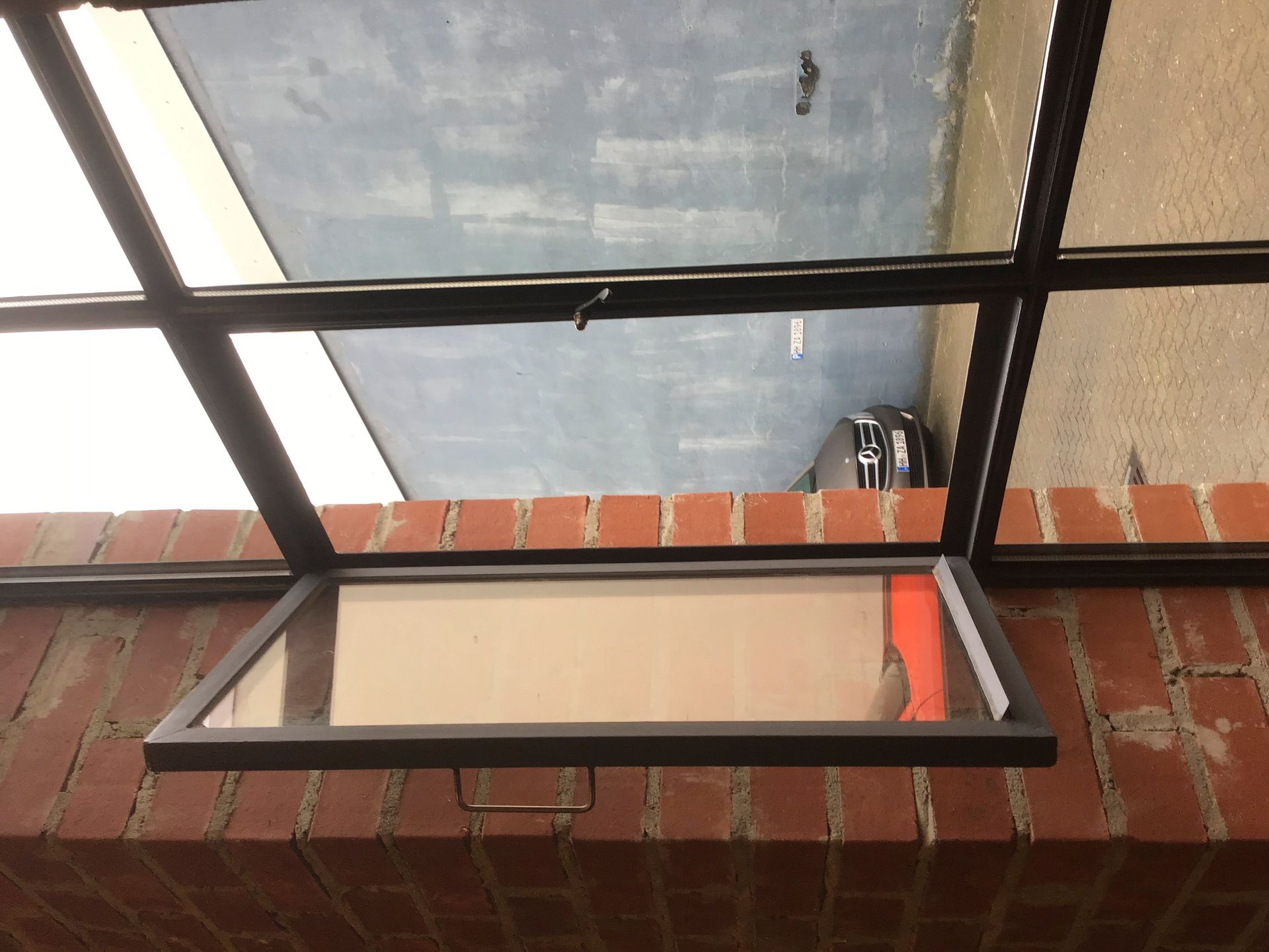 Eine Ziegelwand mit einem offenen Fenster