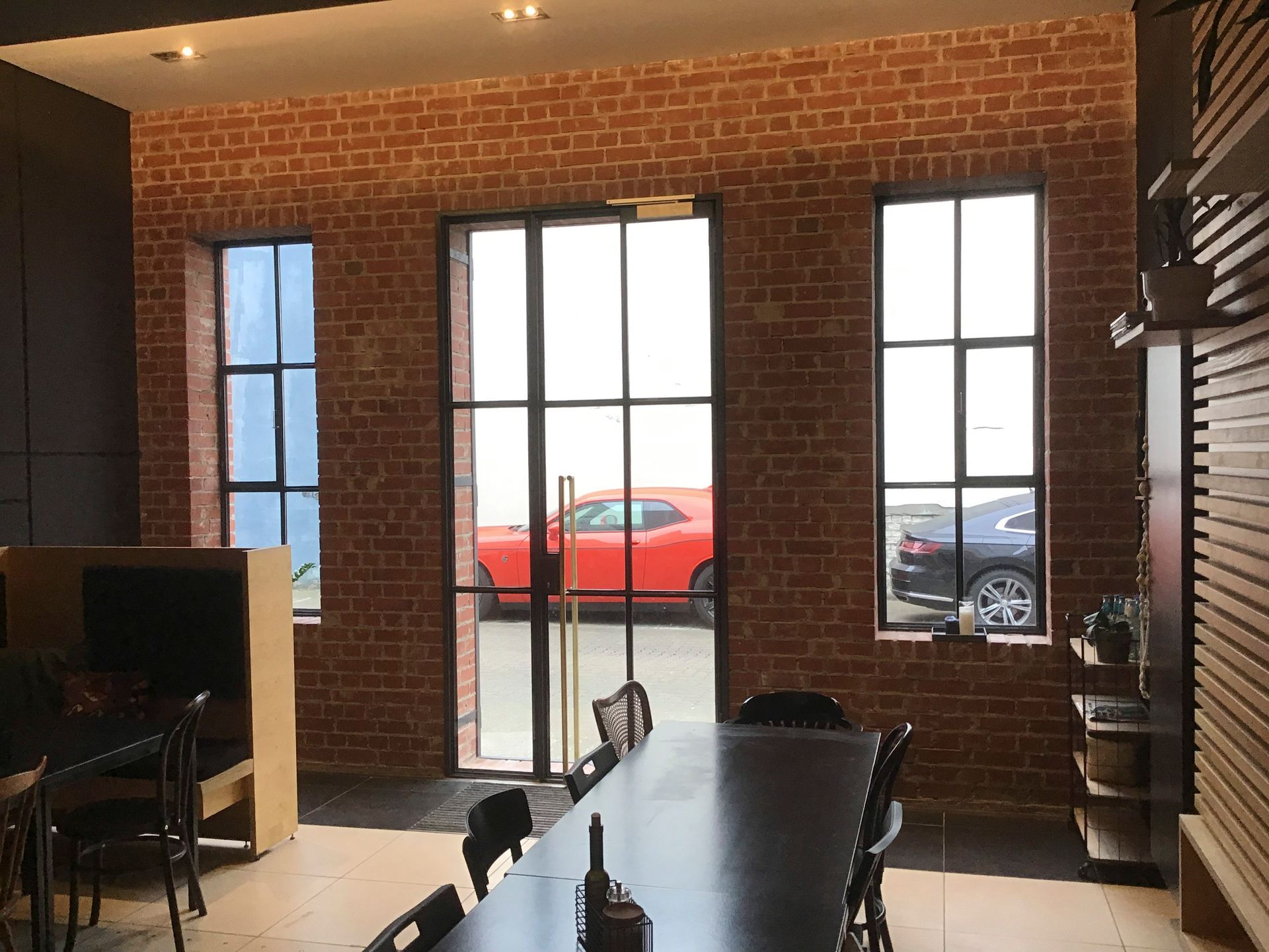 Ein Esszimmer mit einem Tisch und Stühlen und einer Backsteinwand