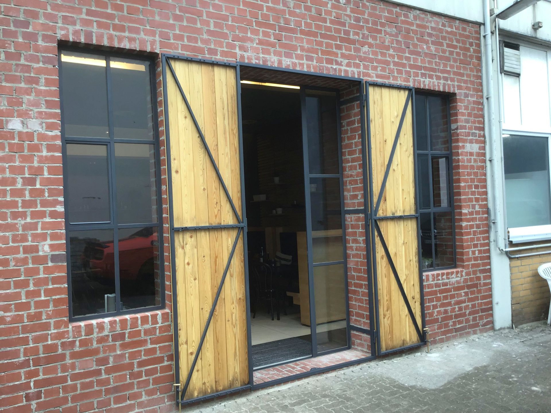 Ein Backsteingebäude mit hölzernen Schiebetüren und Fenstern