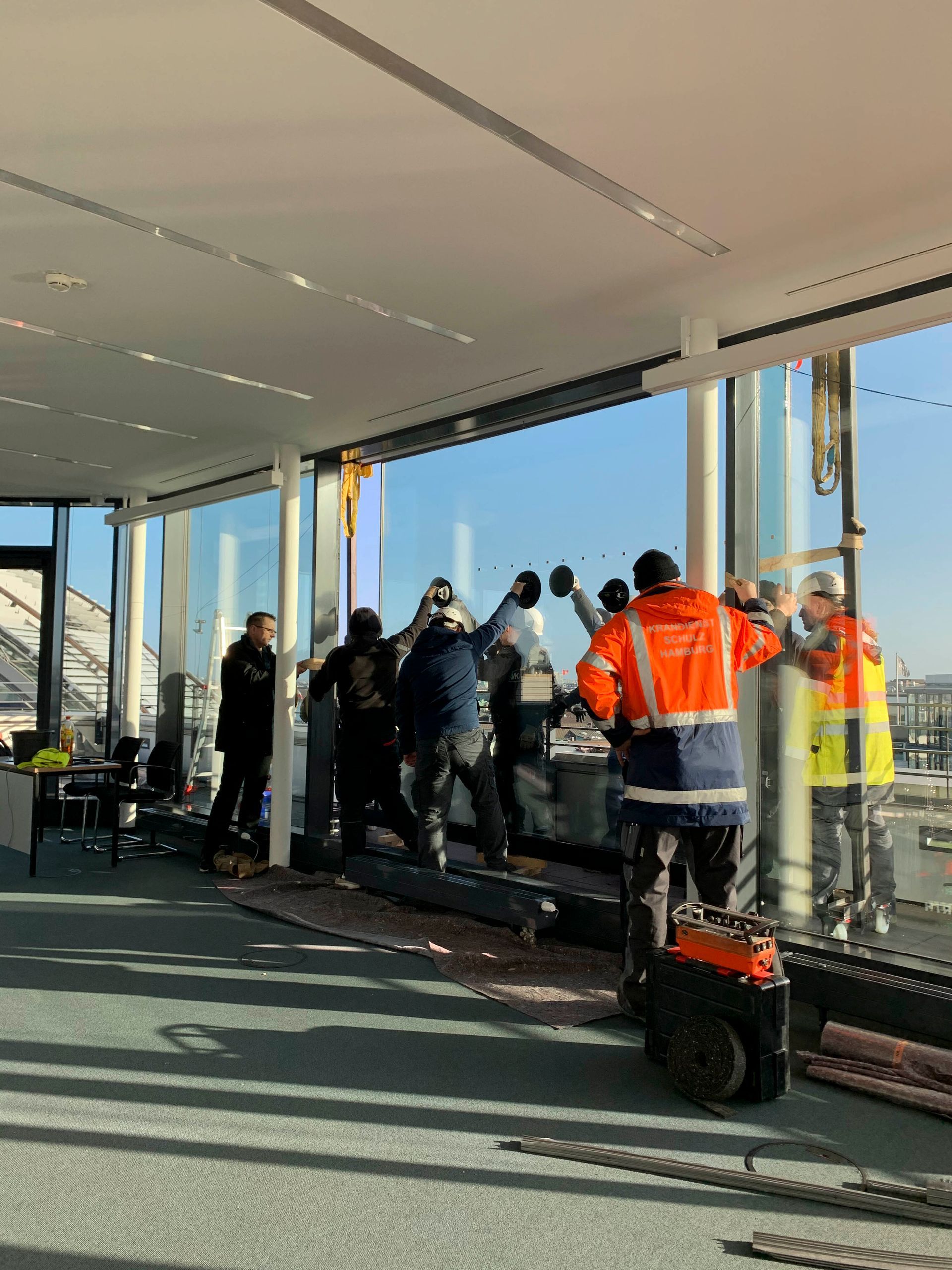 Eine Gruppe von Leuten arbeitet an einem großen Fenster.