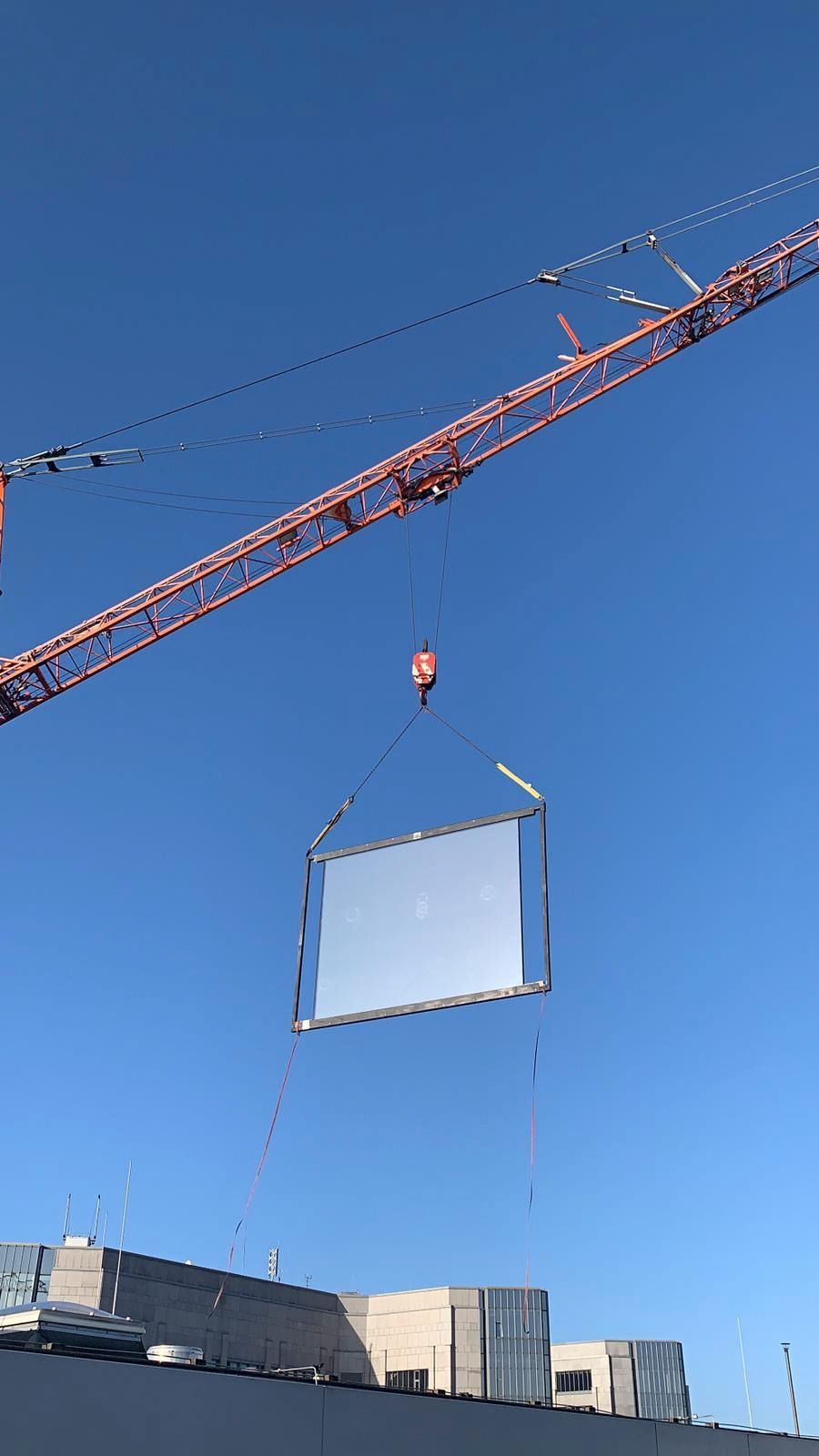 Ein Kran hebt ein großes Stück Holz in die Luft.