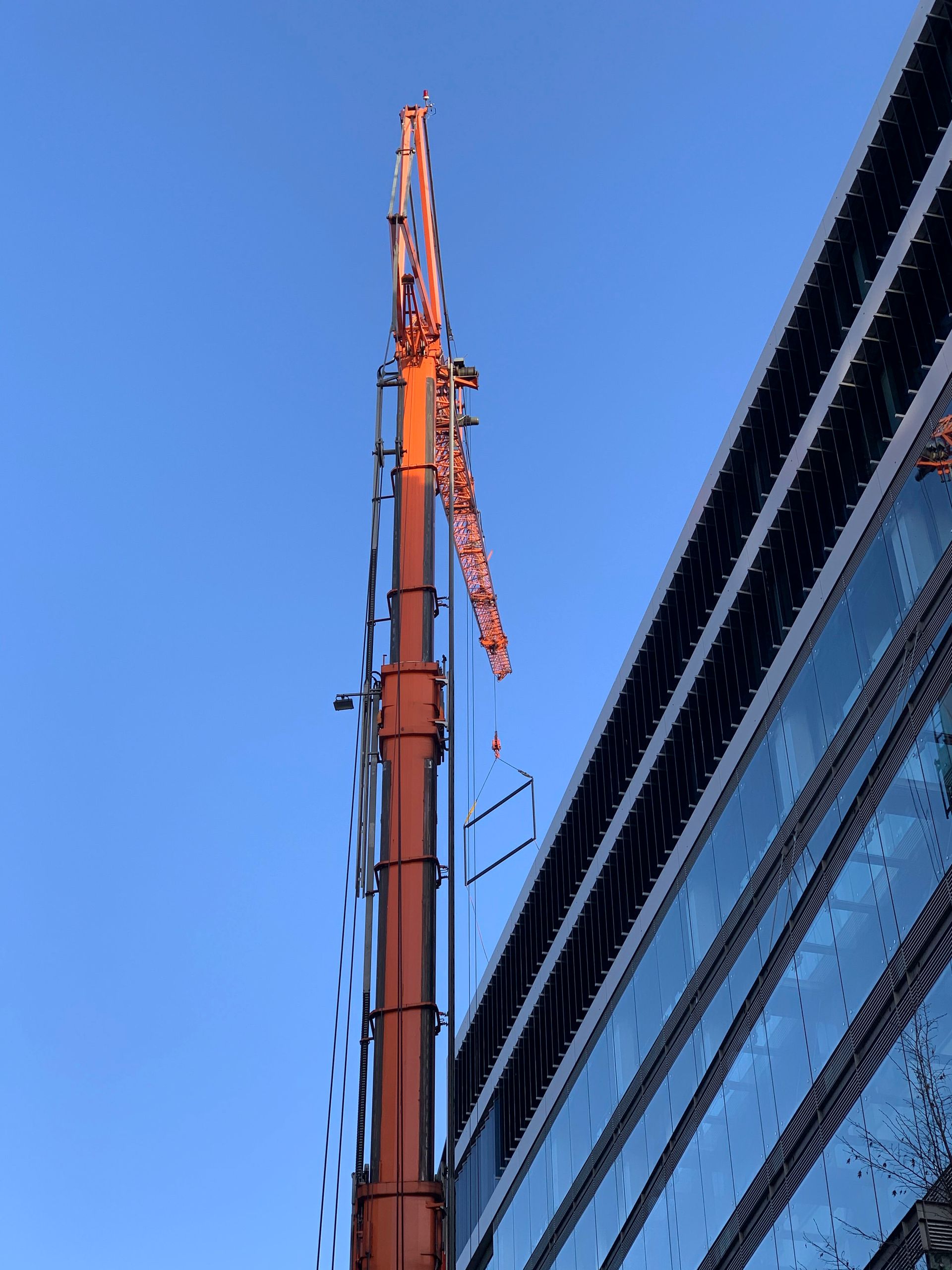 Ein hoher orangefarbener Turm mit einem Kran darauf