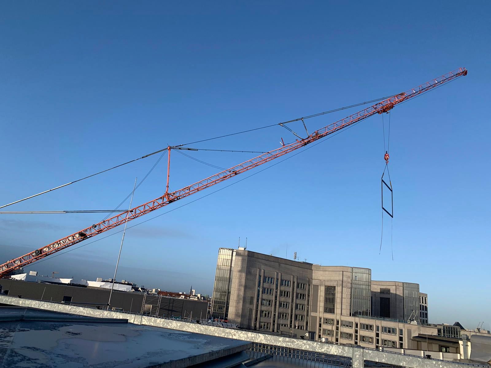 Ein großer Kran steht auf einem im Bau befindlichen Gebäude.