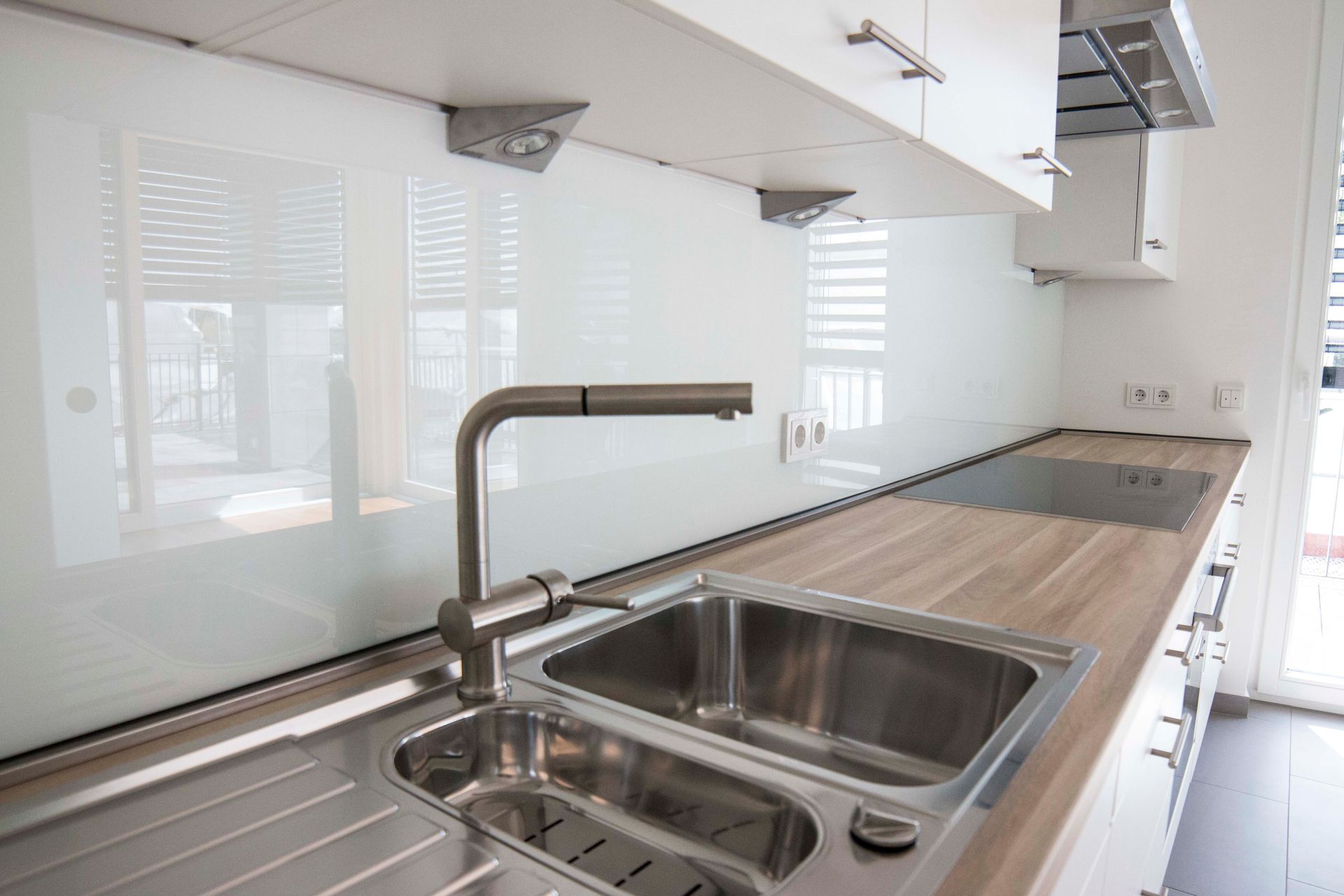 Eine Küche mit Edelstahlspüle und Holzarbeitsplatte.