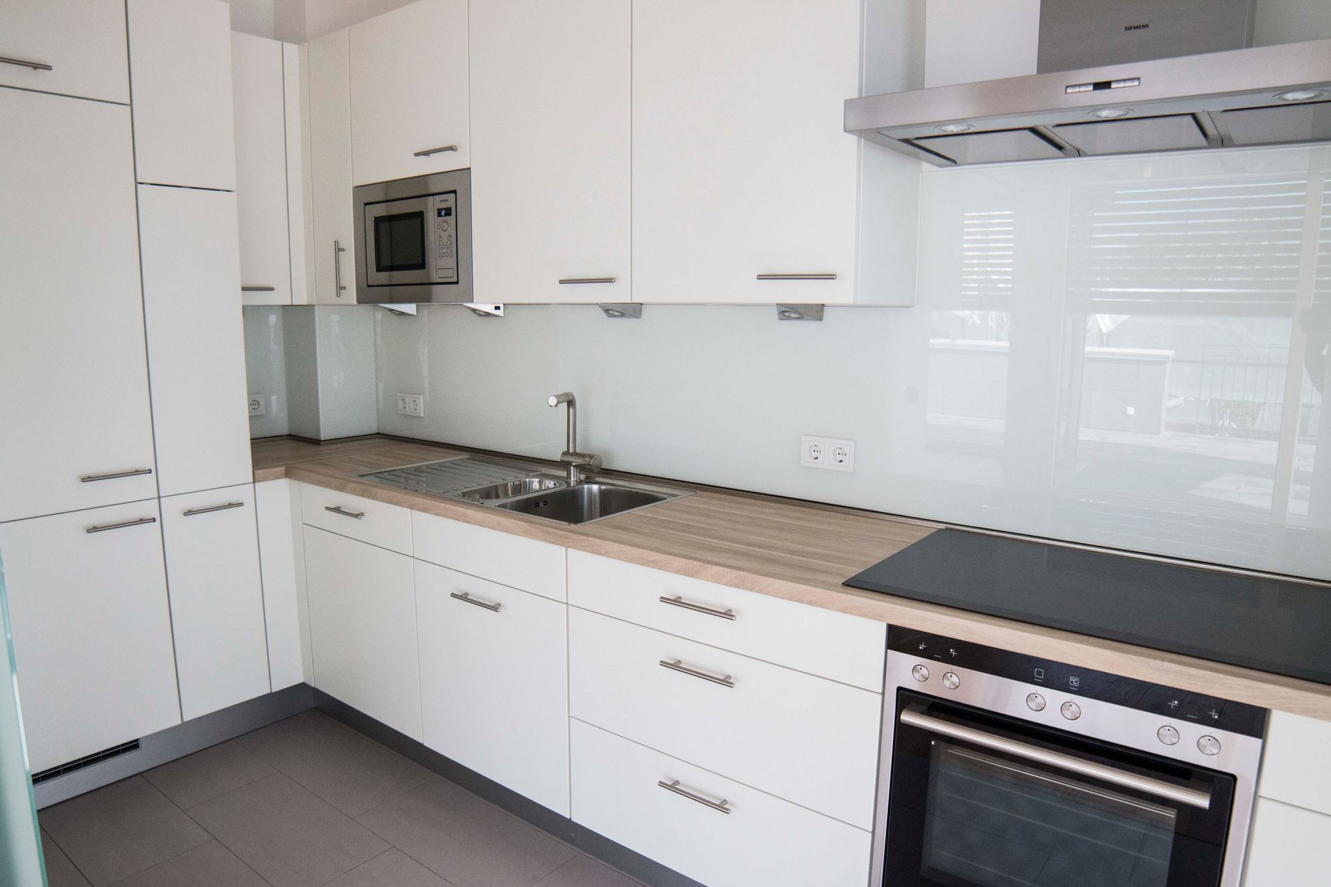 Eine Küche mit weißen Schränken und Geräten aus Edelstahl