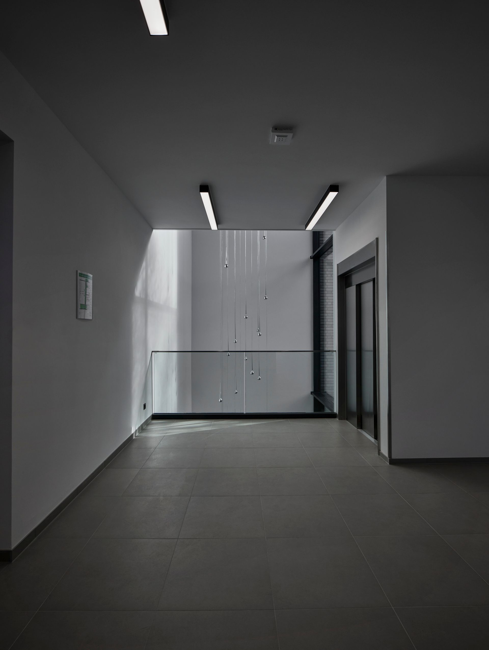 Ein Flur mit Balkon und Aufzügen in einem Gebäude