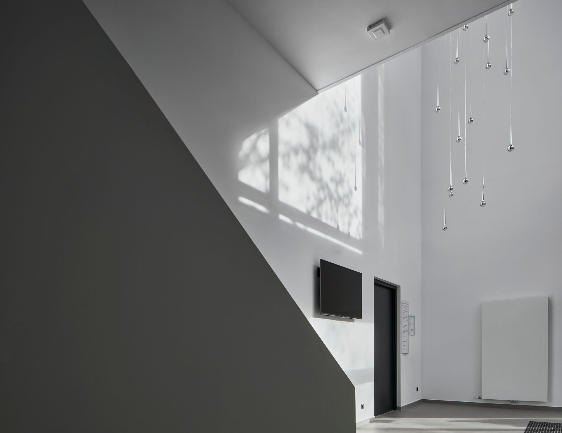 Ein Schwarzweißfoto eines Raumes mit einer Treppe und einem Fenster.