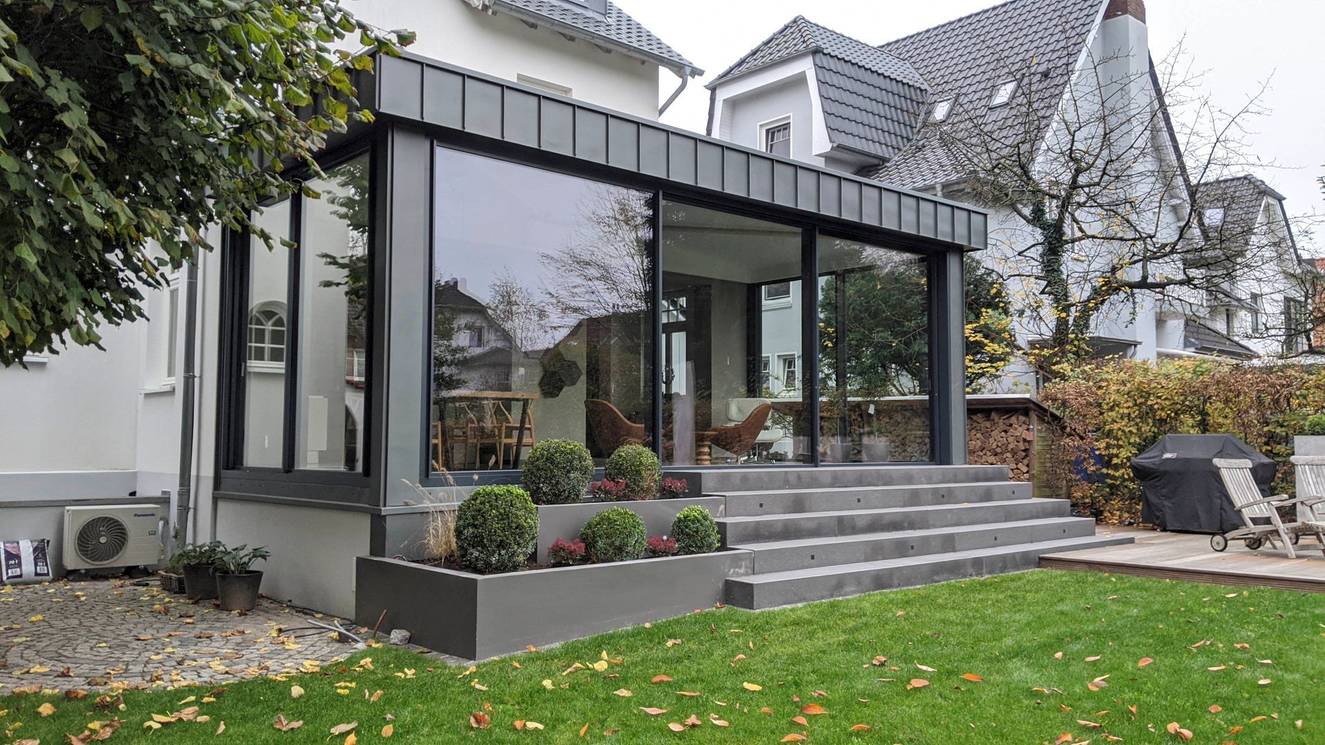 Ein Haus mit einer großen Glasveranda und einer Treppe im Hinterhof.