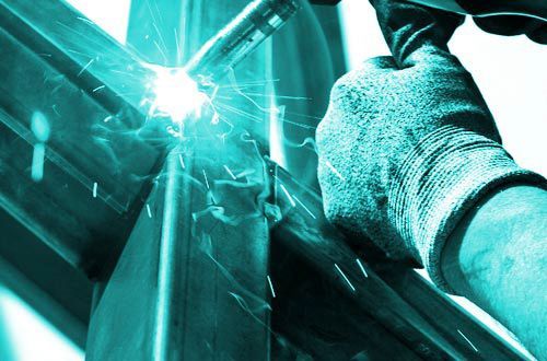 Eine Person schweißt ein Stück Metall mit einem Schweißgerät.