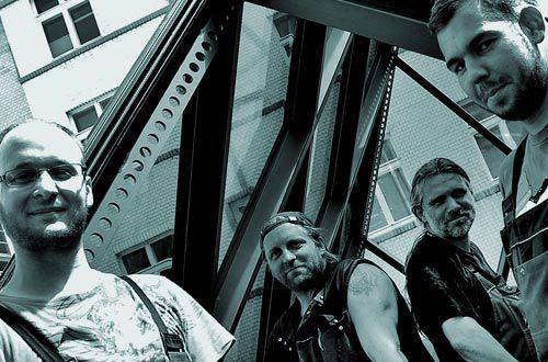 Ein Schwarzweißfoto von vier Männern, die nebeneinander stehen