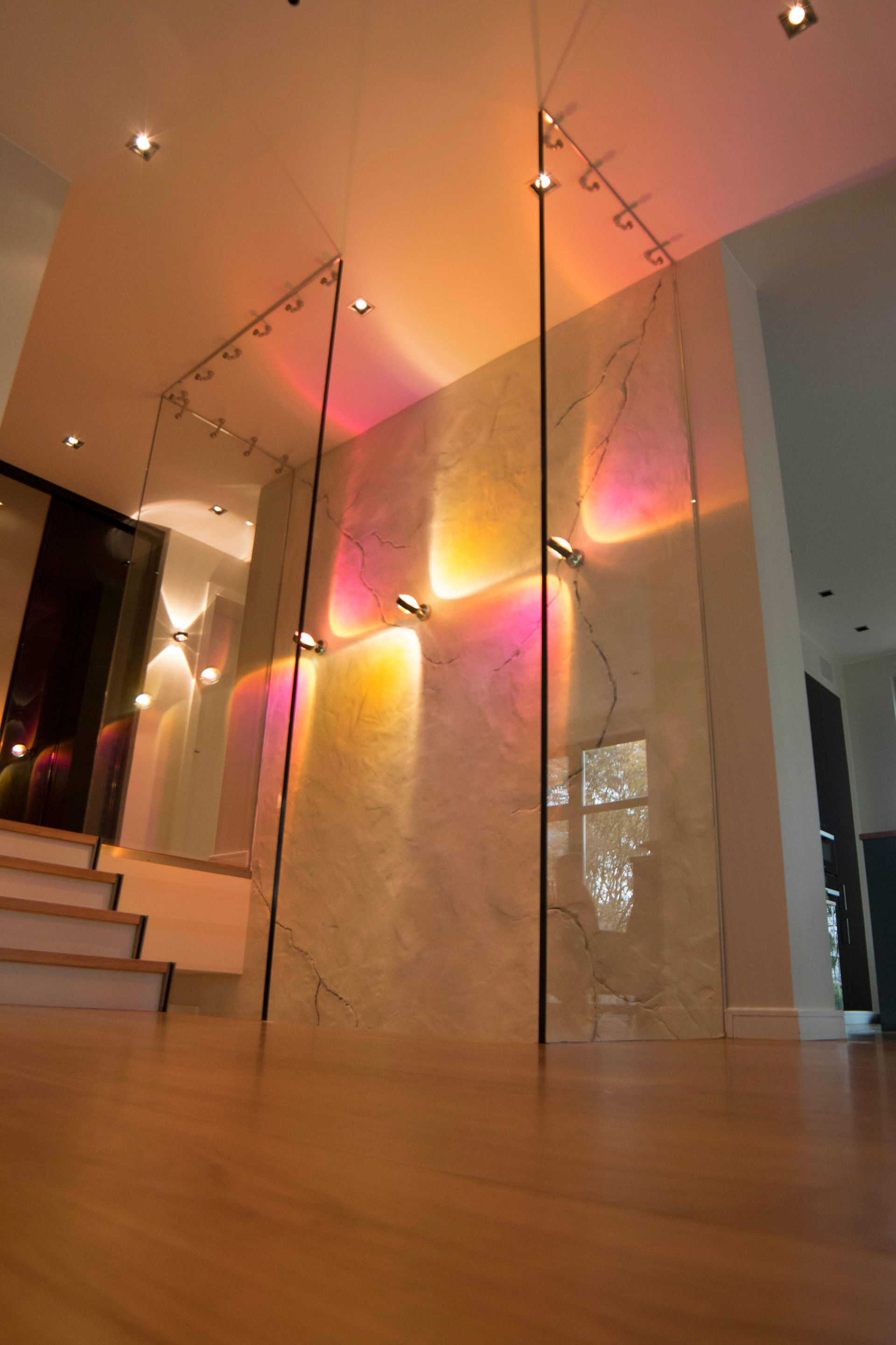 Ein Flur mit Treppen und einer Wand mit farbigen Lichtern darauf.