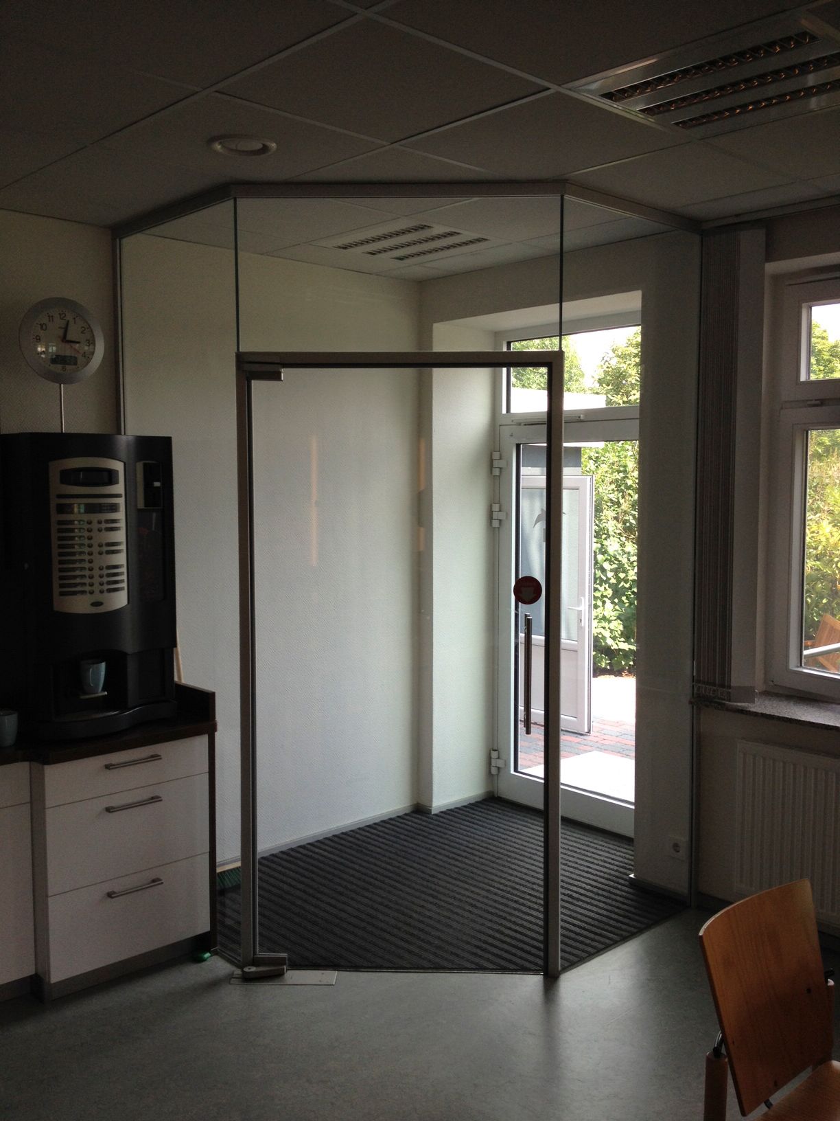 Ein Zimmer mit einer Uhr an der Wand und einer Kaffeemaschine
