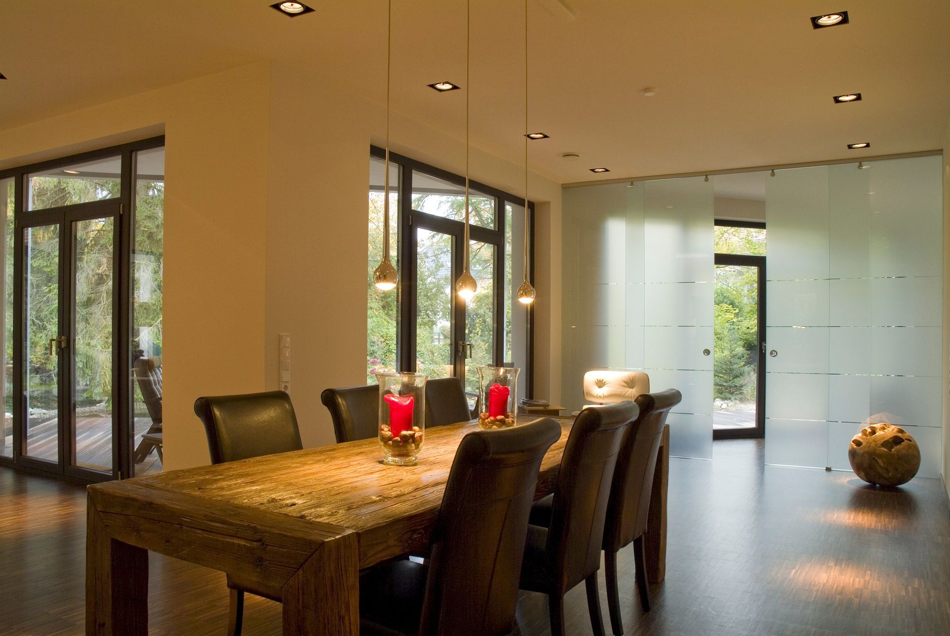 Ein Esszimmer mit Tisch und Stühlen und einer Glaswand