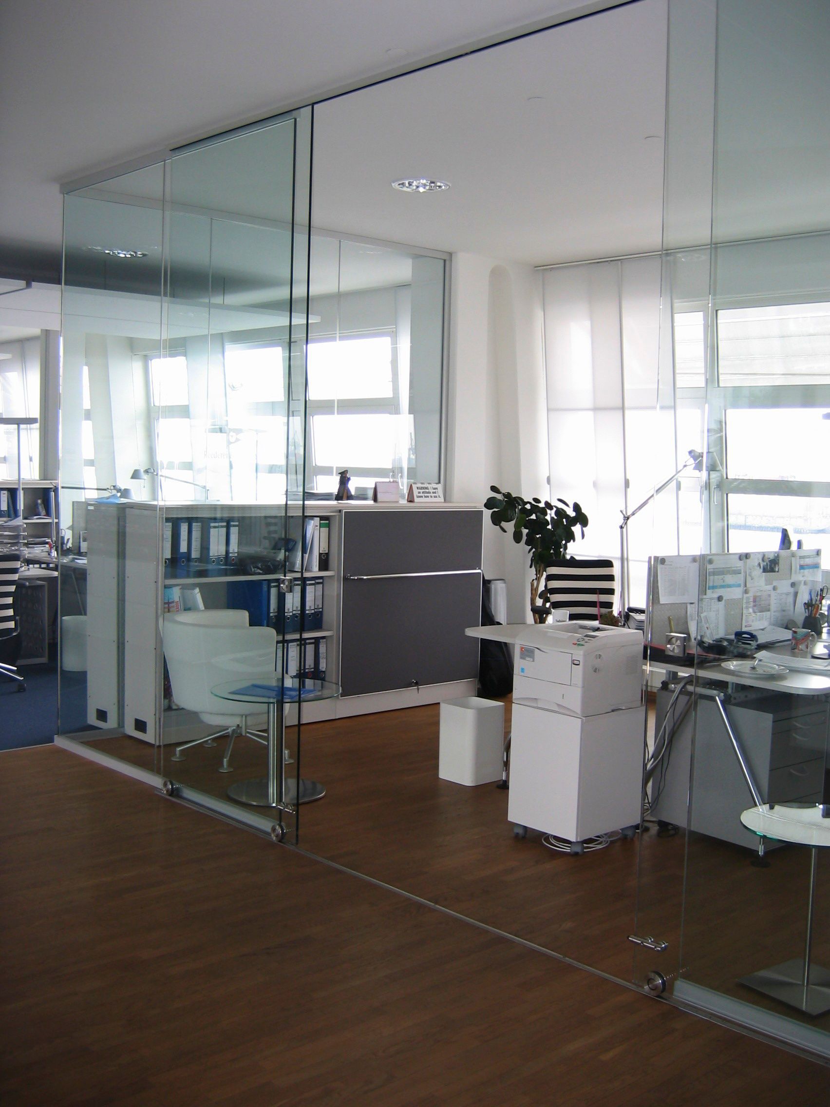 Ein Raum mit vielen Fenstern und einer Glaswand