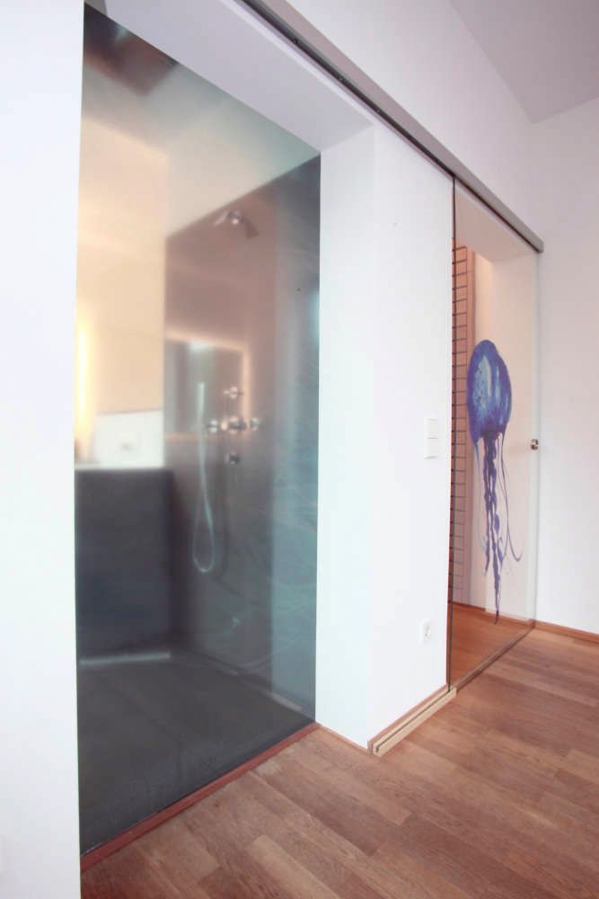 Ein Badezimmer mit Glasschiebetüren und einer Qualle an der Wand