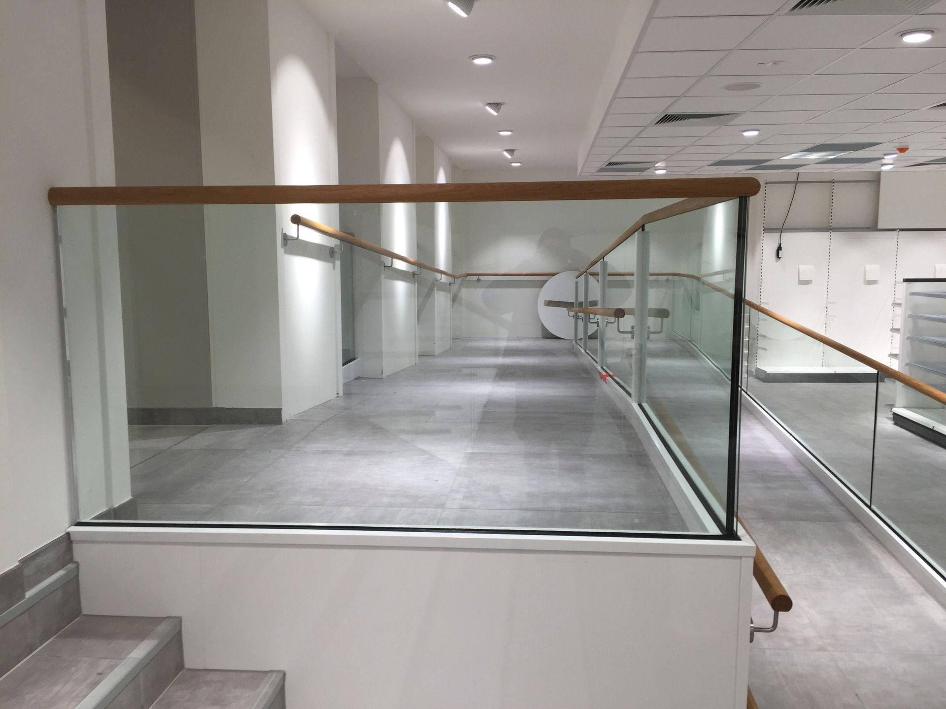 Ein langer Flur mit Treppe und Glasgeländer