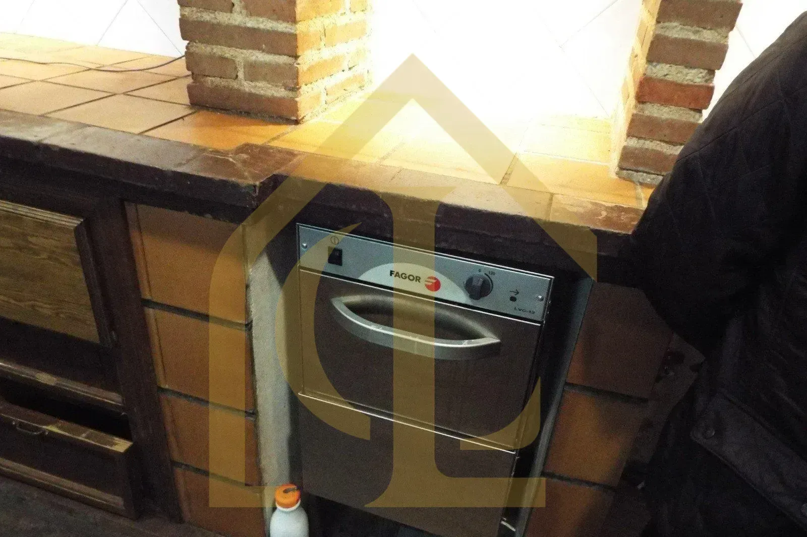 Un horno empotrado en un mueble de cocina de madera con detalles de ladrillo.