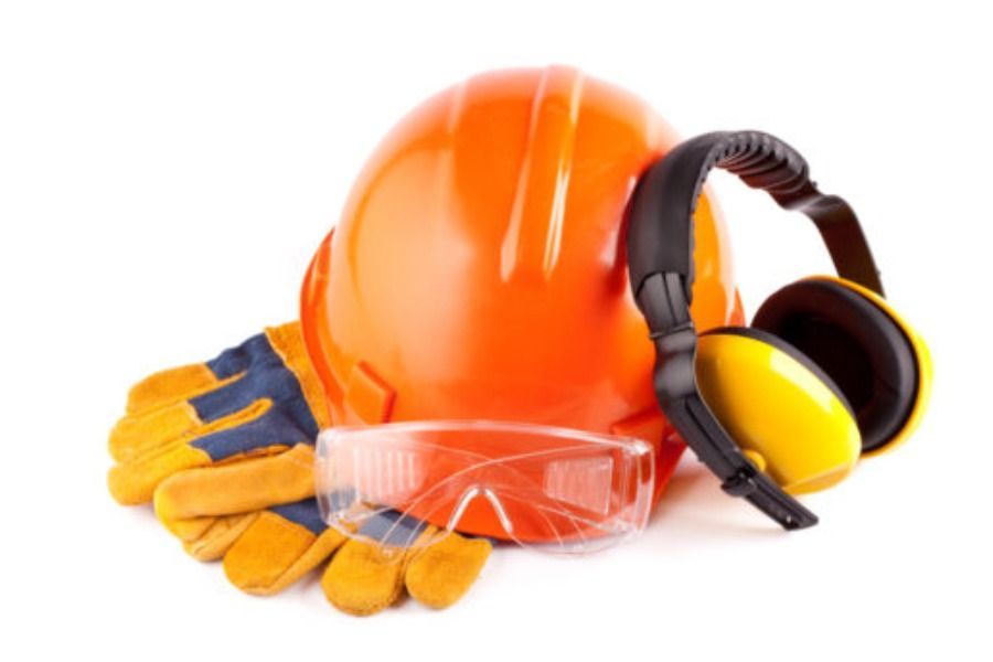 Casco de seguridad de color naranja, protectores auditivos, gafas de seguridad y guantes de trabajo, probablemente para construcción o seguridad industrial.