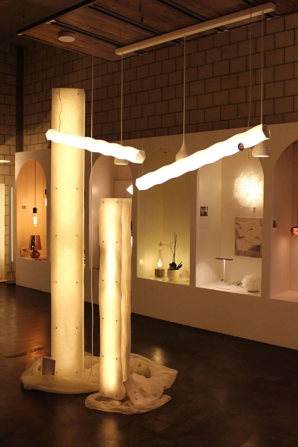Moderne Kunstinstallation mit leuchtend weissen Röhren und hohen beleuchteten Säulen in einem Galerieraum