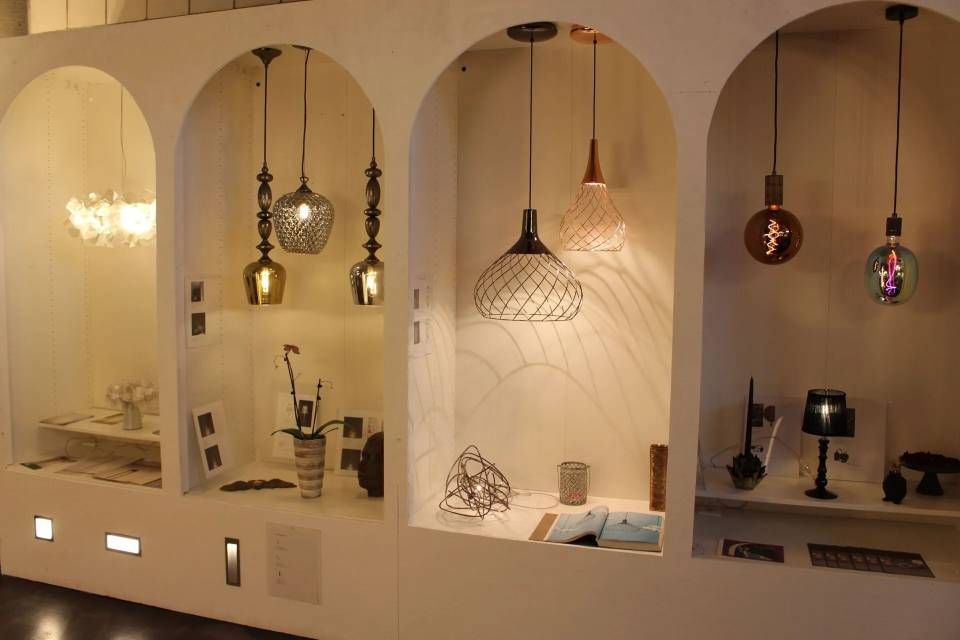 Innenansicht von Hängeleuchten in gewölbten Wandnischen, warm beleuchteter Ausstellungsraum mit kleinen Dekorationselementen