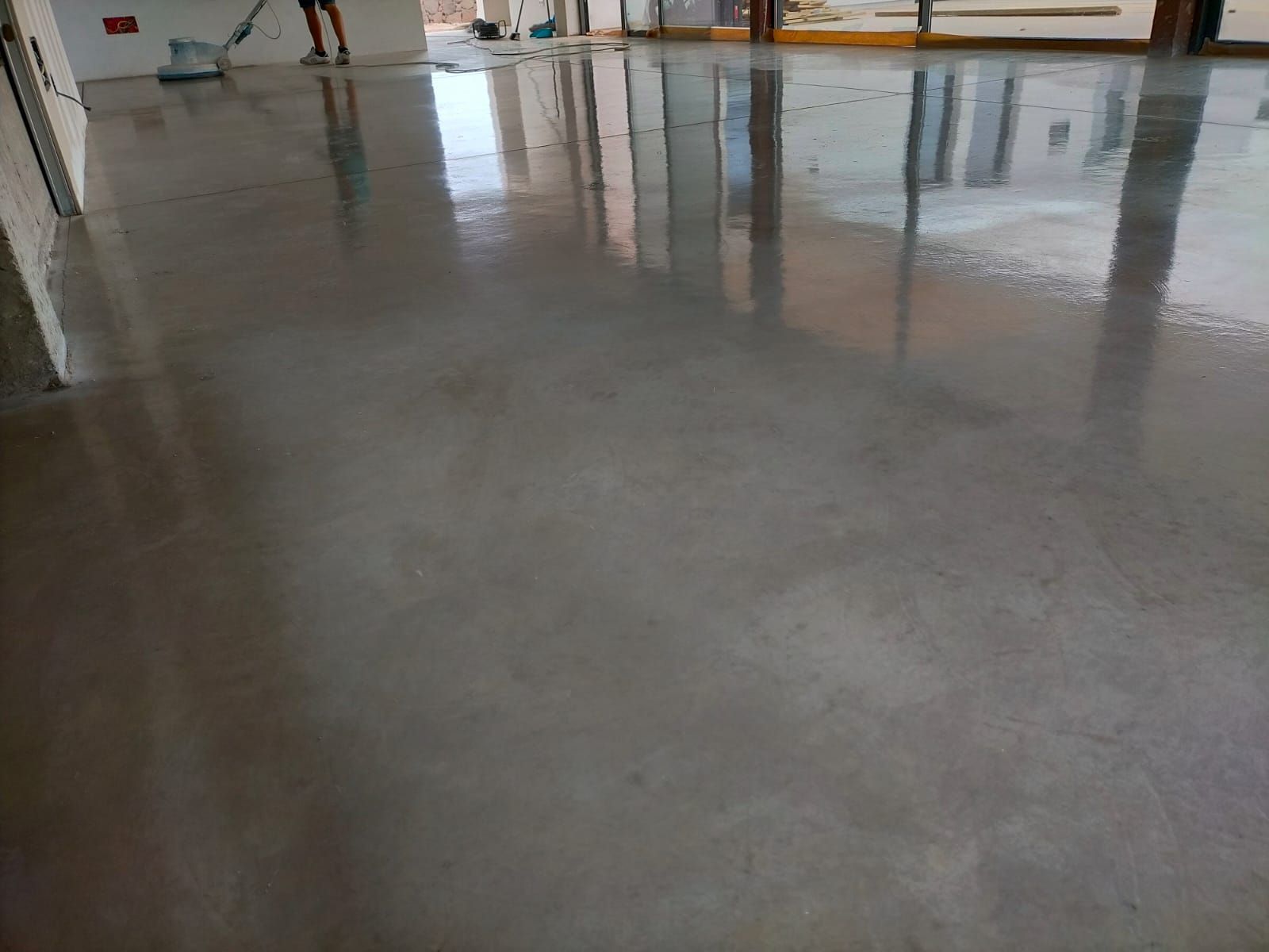 Una persona está limpiando un piso de concreto con una aspiradora.