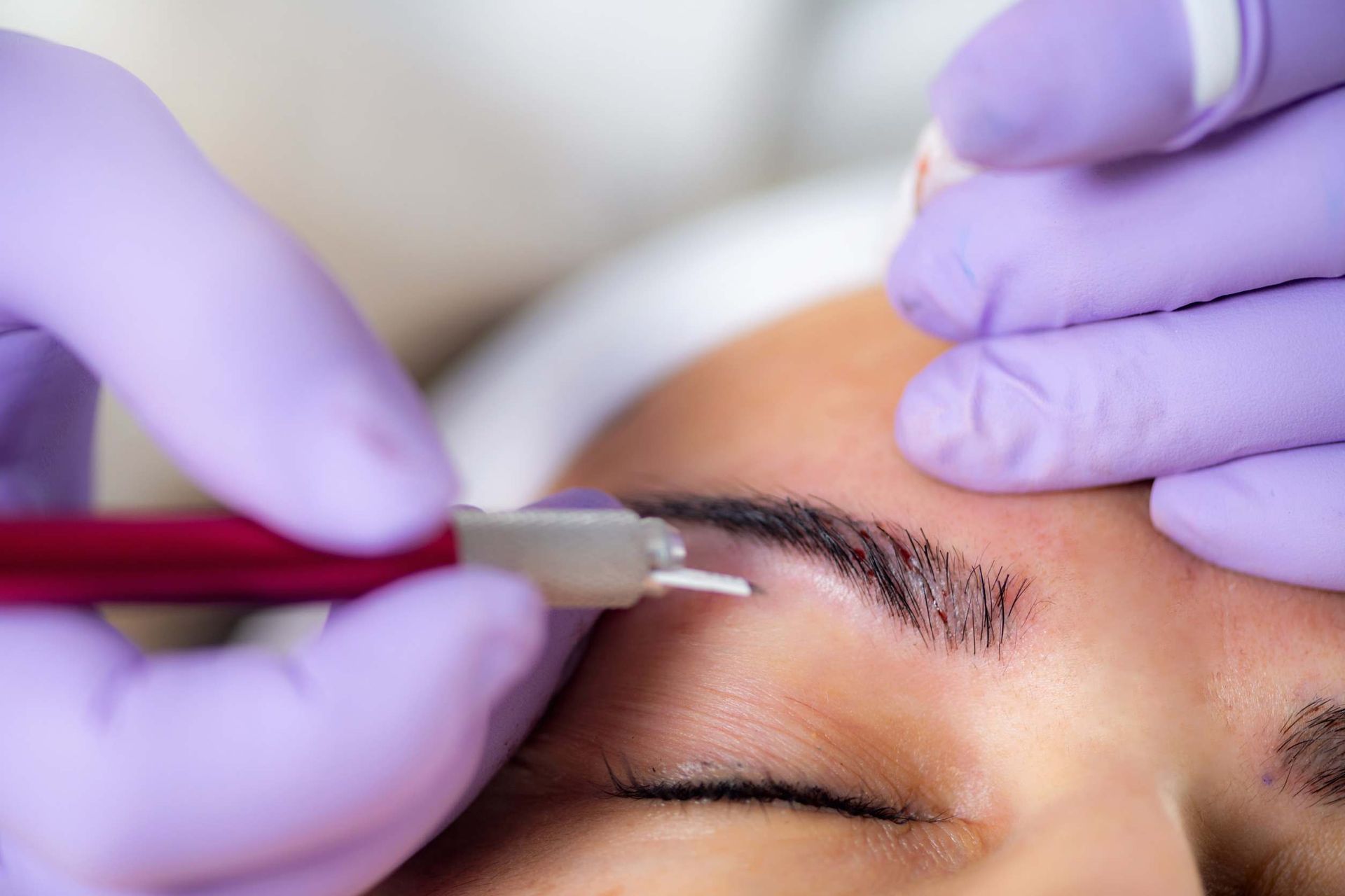 Una mujer se está haciendo un tatuaje de maquillaje permanente en las cejas.
