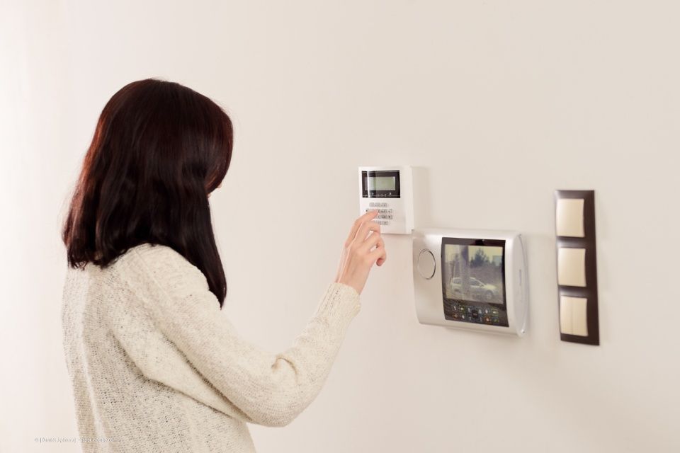Elektro Wölfle – eine Frau bedient eine Klimaanlage über ein Wandpanel