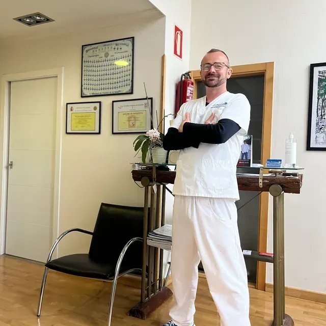 Un hombre de pie en una habitación con los brazos cruzados.