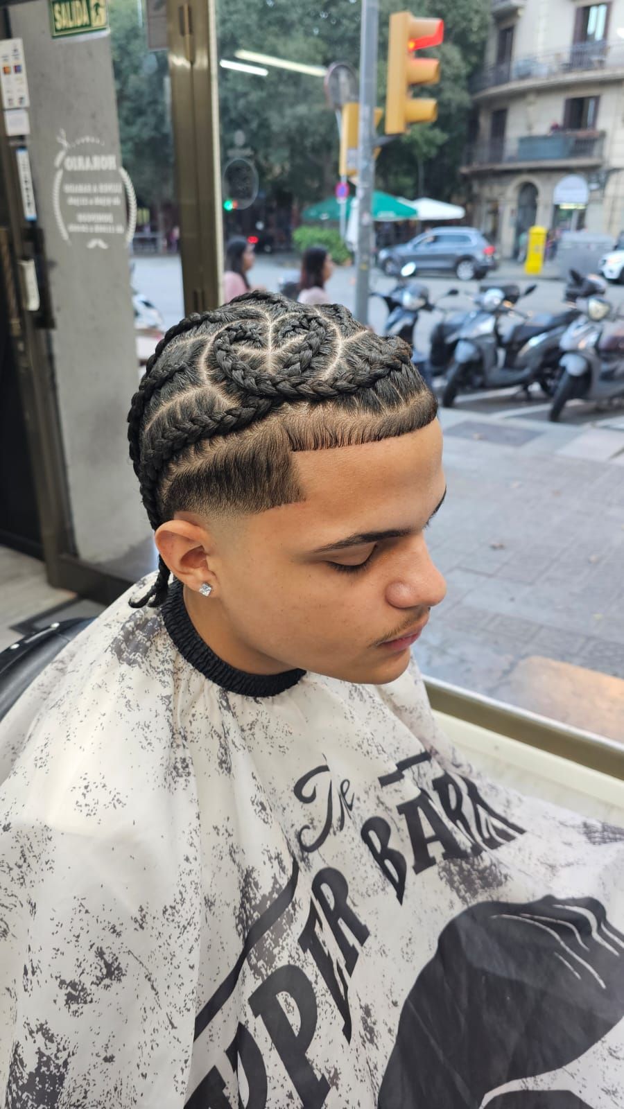 Una persona con capa de barbero, luciendo un corte de pelo degradado 