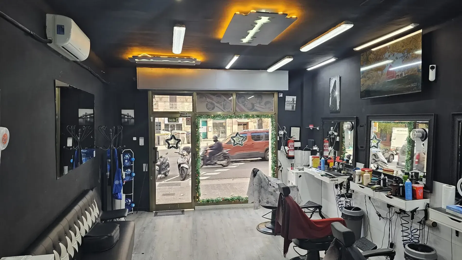 El interior de una barbería moderna cuenta con paredes negras, estaciones 