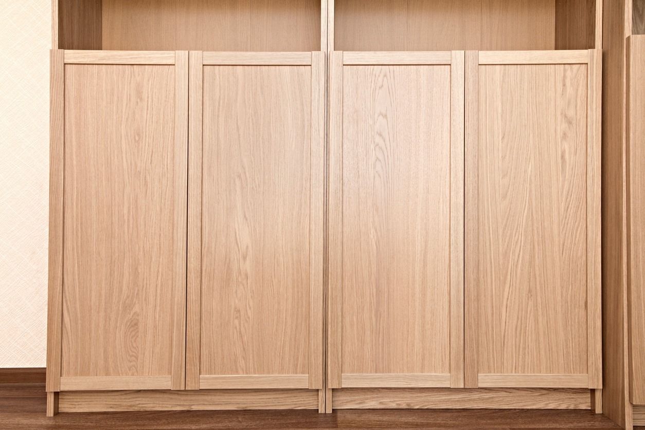 Mueble de madera de roble claro con cuatro puertas y estantes superiores.