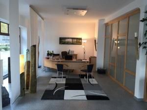 Ein Zimmer mit einem Schreibtisch und Stühlen darin