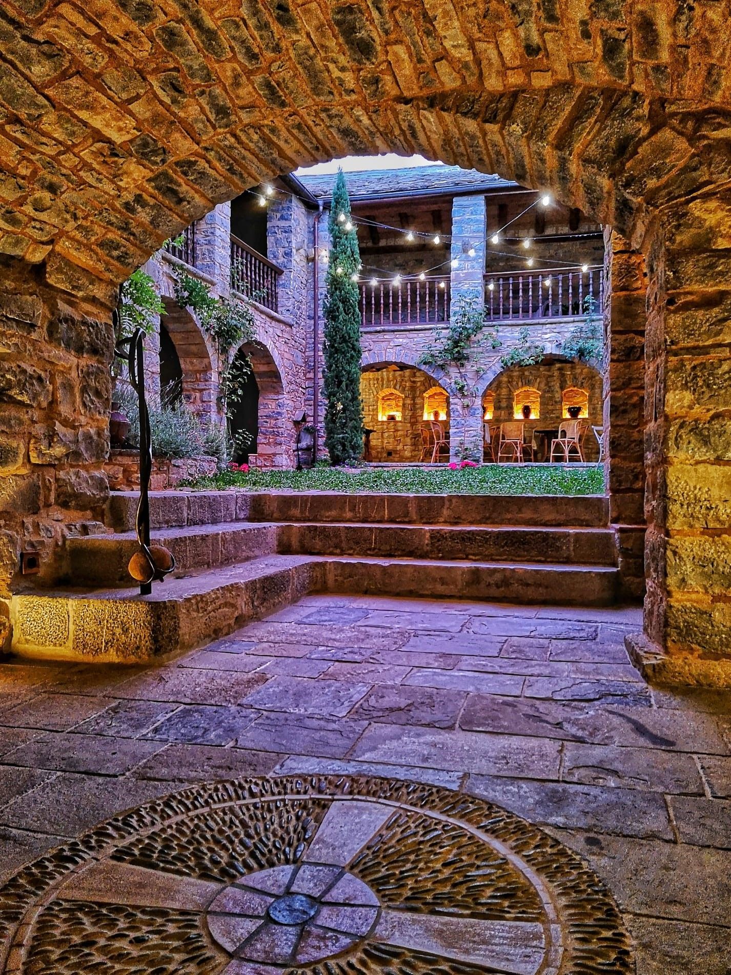 Un arco de piedra que conduce a un edificio con escaleras que conducen hasta él.