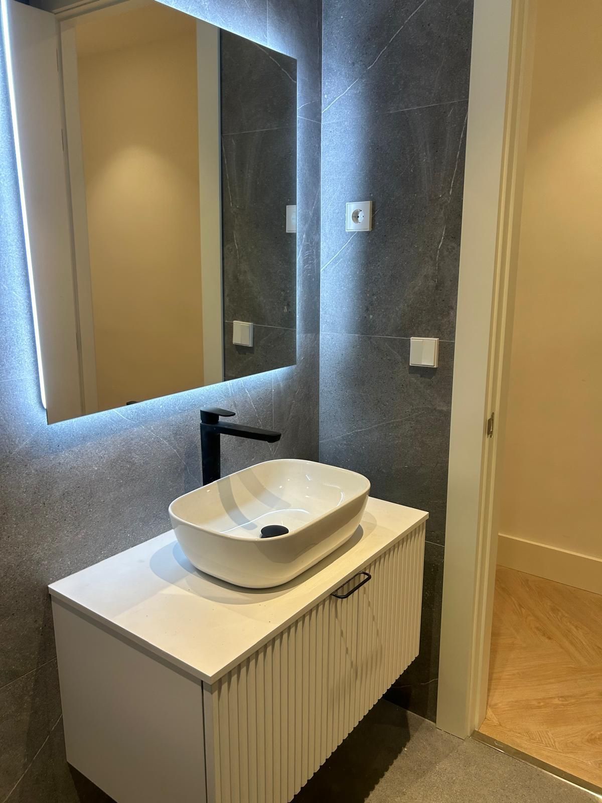 Un baño con lavabo y espejo.