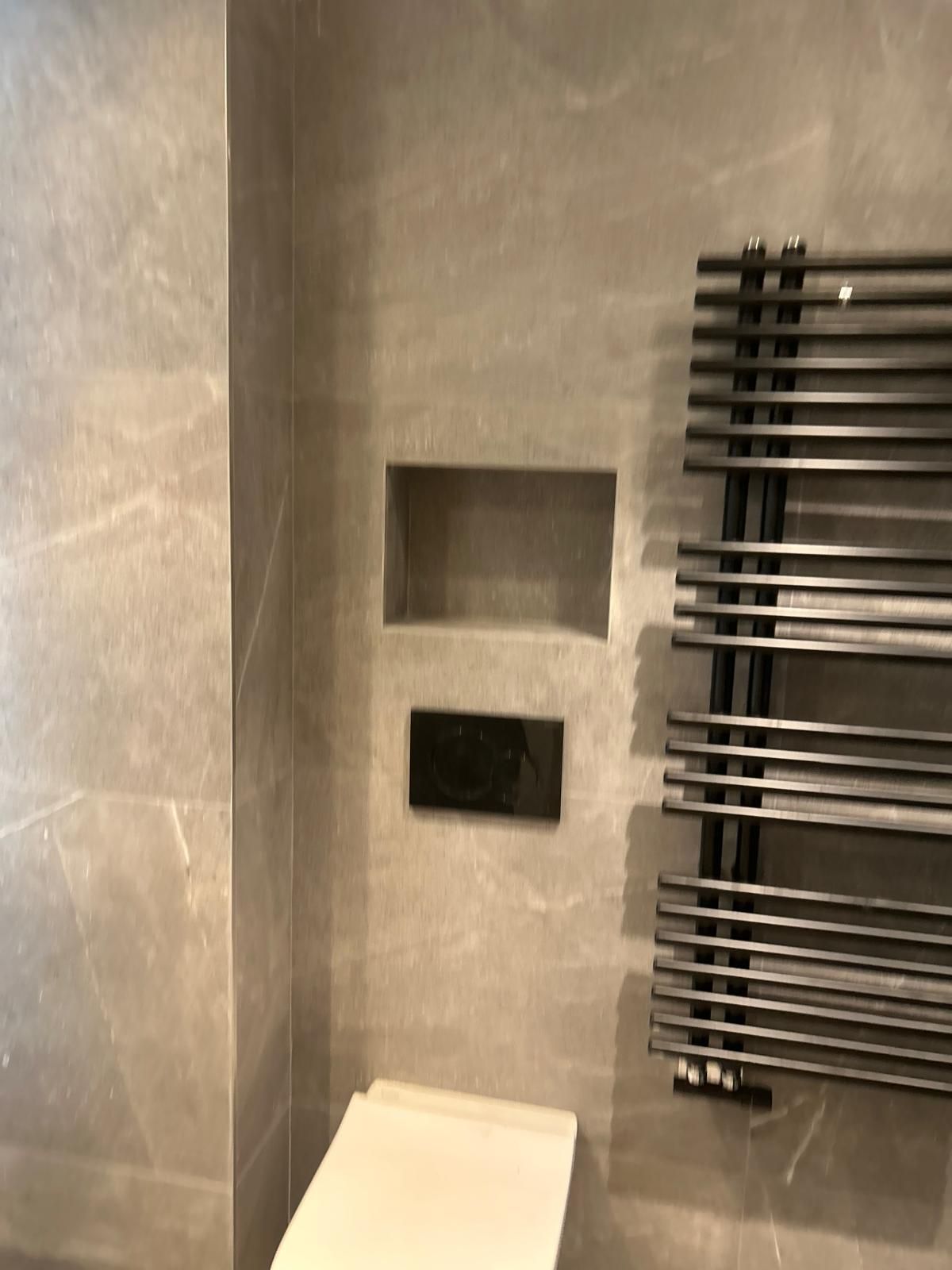 Un baño con inodoro y toallero en la pared.