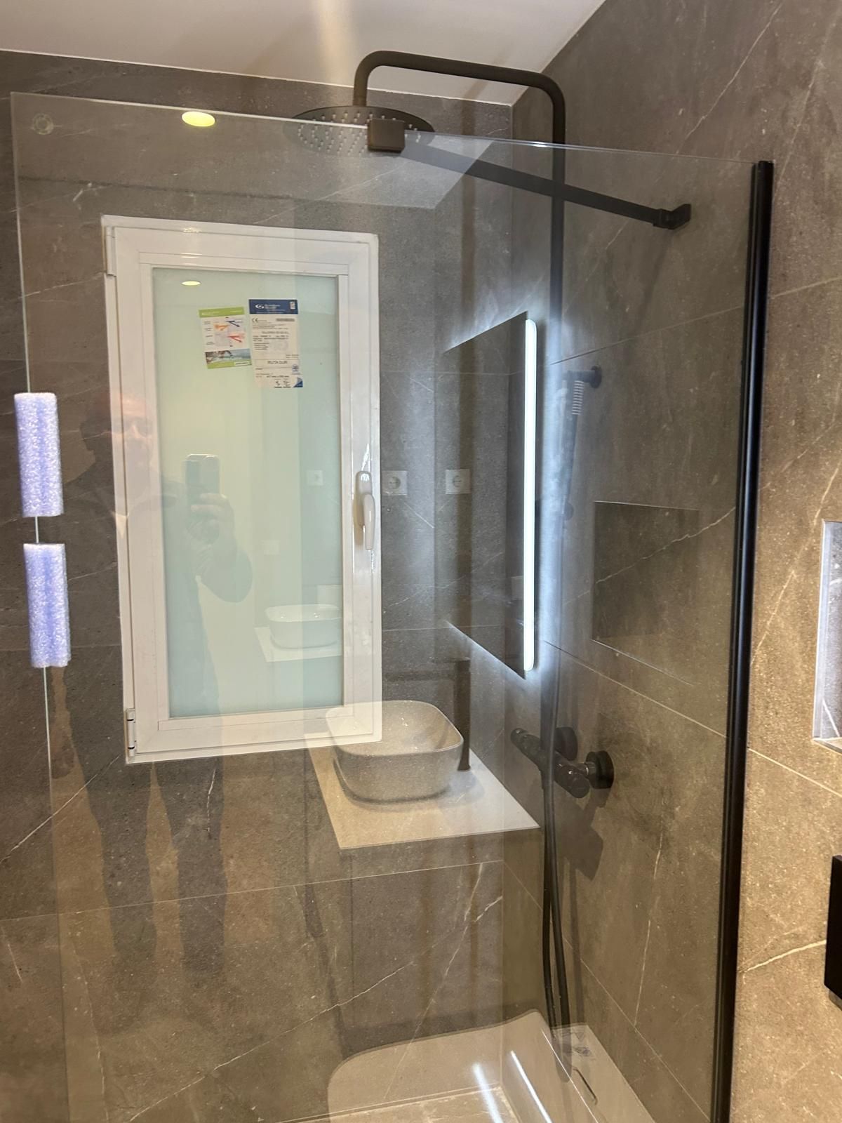 Un baño con lavabo, inodoro, ducha y ventana.