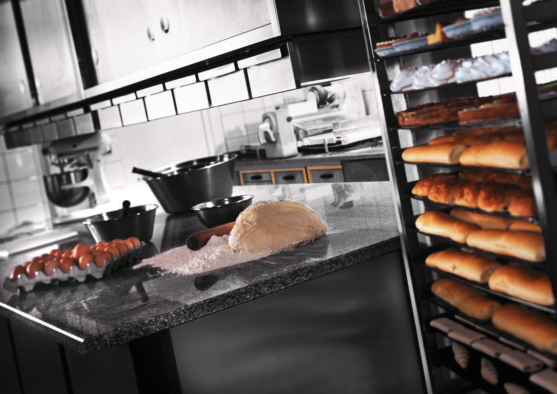 Cuisine avec pain et farine sur le plan de travail et au premier plan des pâtisseries sorties du four