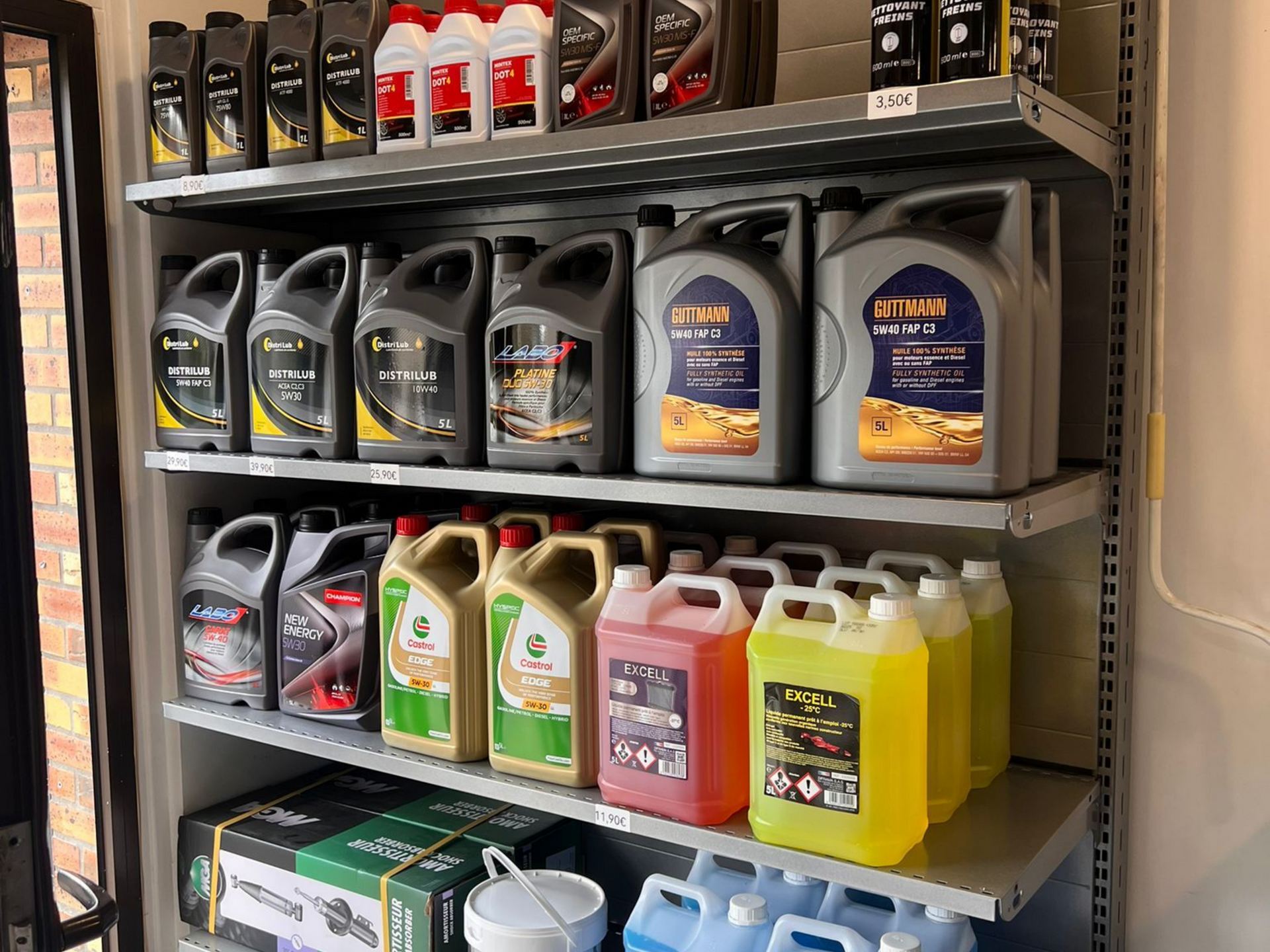 Des étagères garnies de divers liquides automobiles, notamment de l'huile à moteur, du liquide de refroidissement et du liquide lave-glace.
