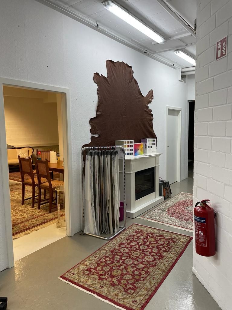 ein Raum mit Teppichen und einem Feuerlöscher an der Wand