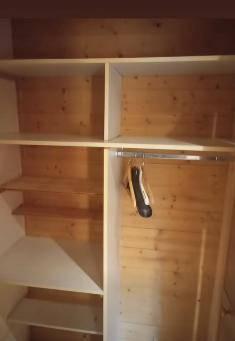 Placard en bois vide avec étagères et tringle à vêtements.