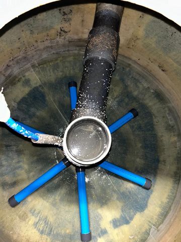 À l'intérieur d'un filtre à sable, des tuyaux bleus rayonnent à partir d'une ouverture métallique centrale.