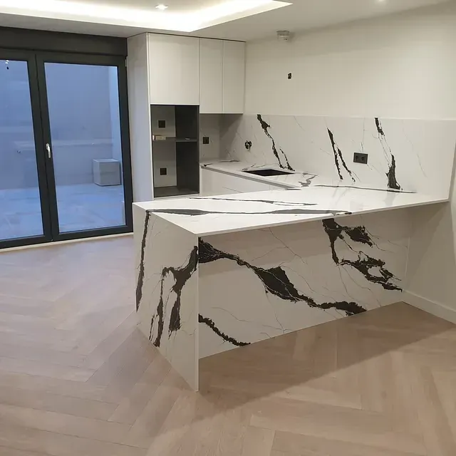 Una cocina con encimera de mármol y puertas corredizas de vidrio.