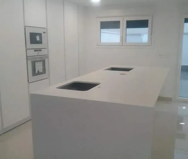 Una cocina con una gran isla y dos fregaderos.