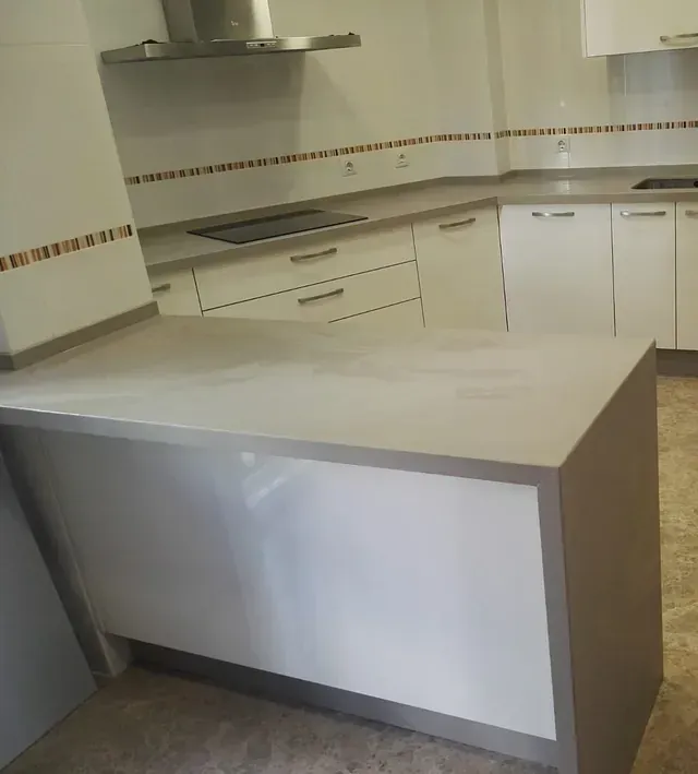 Una cocina con gabinetes blancos y electrodomésticos de acero inoxidable.