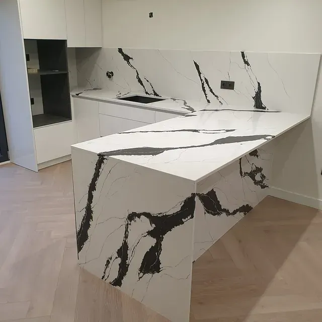 Una cocina con encimera de mármol blanco y negro.