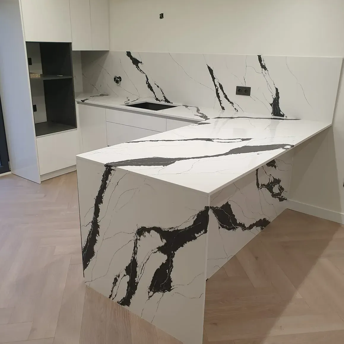 Una cocina con encimera de mármol blanco y negro.