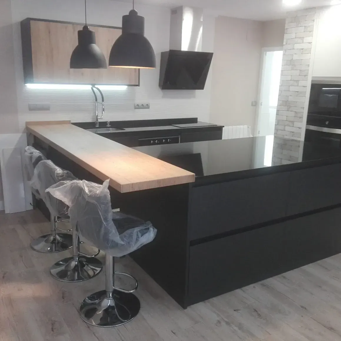 Una cocina con una gran isla y taburetes.