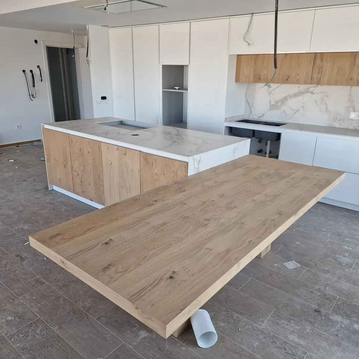 Una cocina con una gran mesa de madera en el medio.